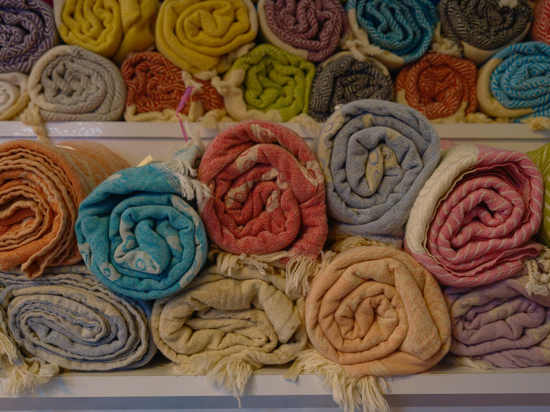 Rolled blankets stacked on shelves