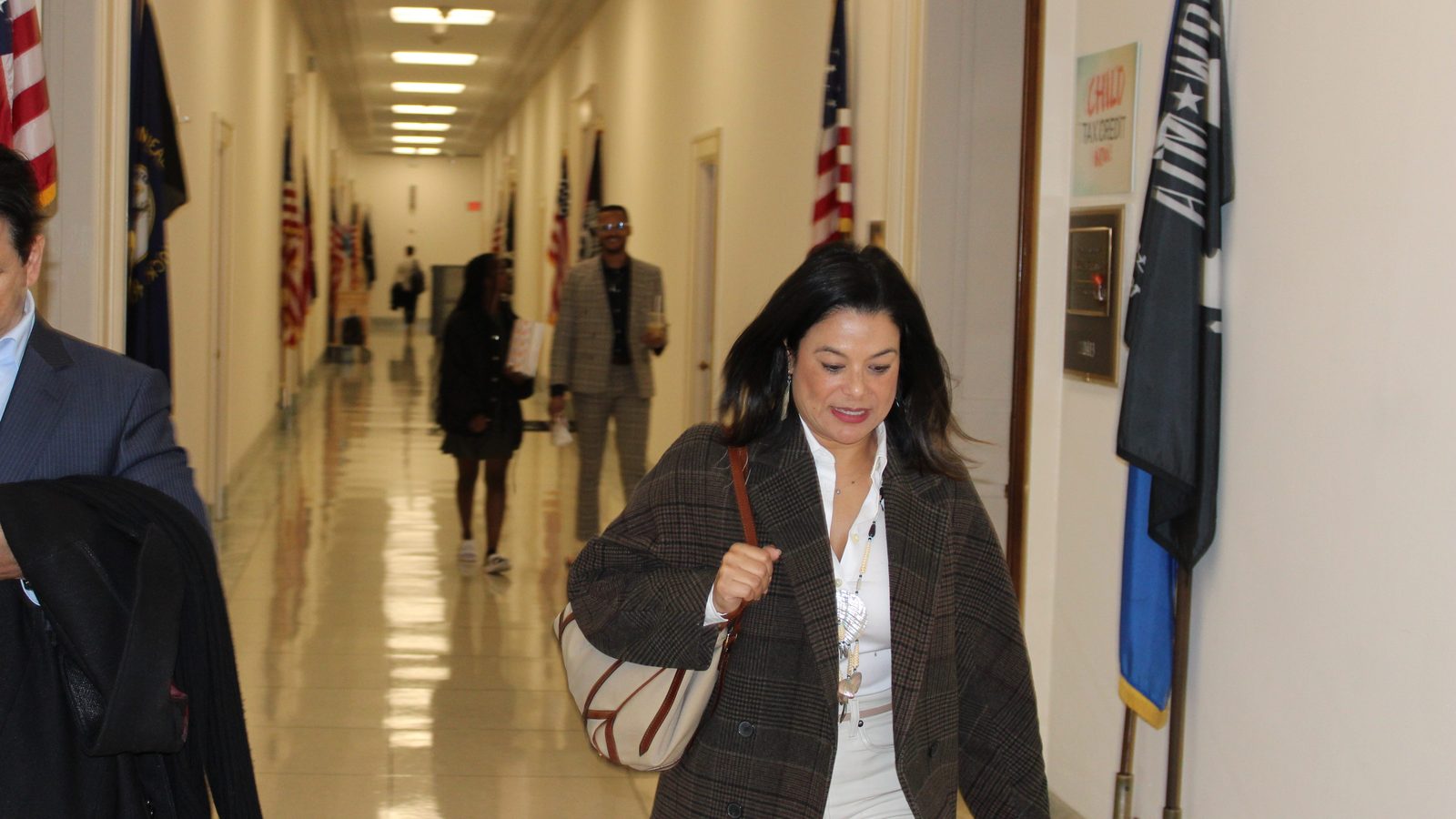Charlene Nijmeh walking down a government office hallway lined with flags
