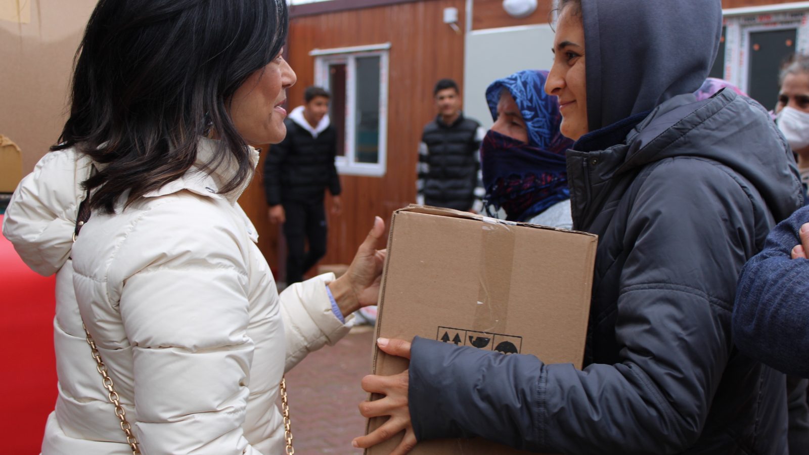Charlene Nijmeh handing a box of relief supplies to a woman in Türkiye